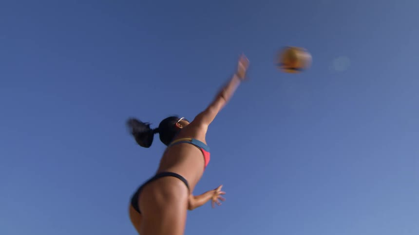 Woman playing volleyball under the glare of the sun