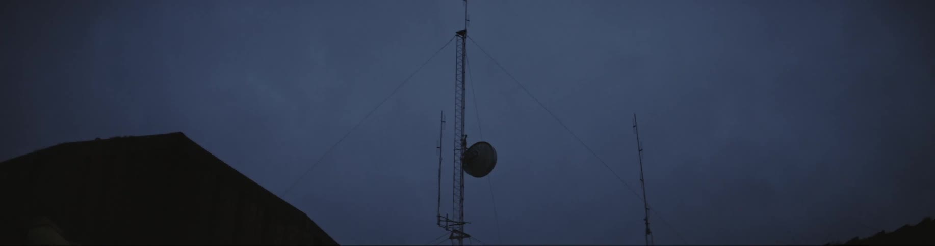 A pole with wires attached to it attached to a house