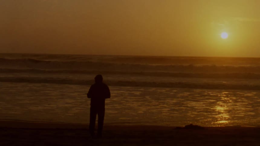 A person looking out over the ocean under duskdawn