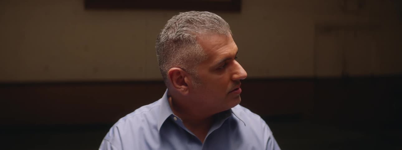 A shot of man having a discussion with two people offscreen