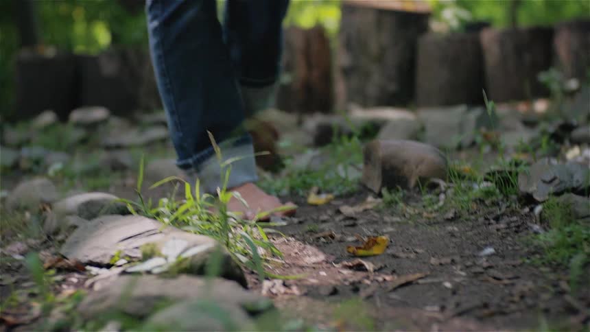 A barefoot woman walking along a dirt path