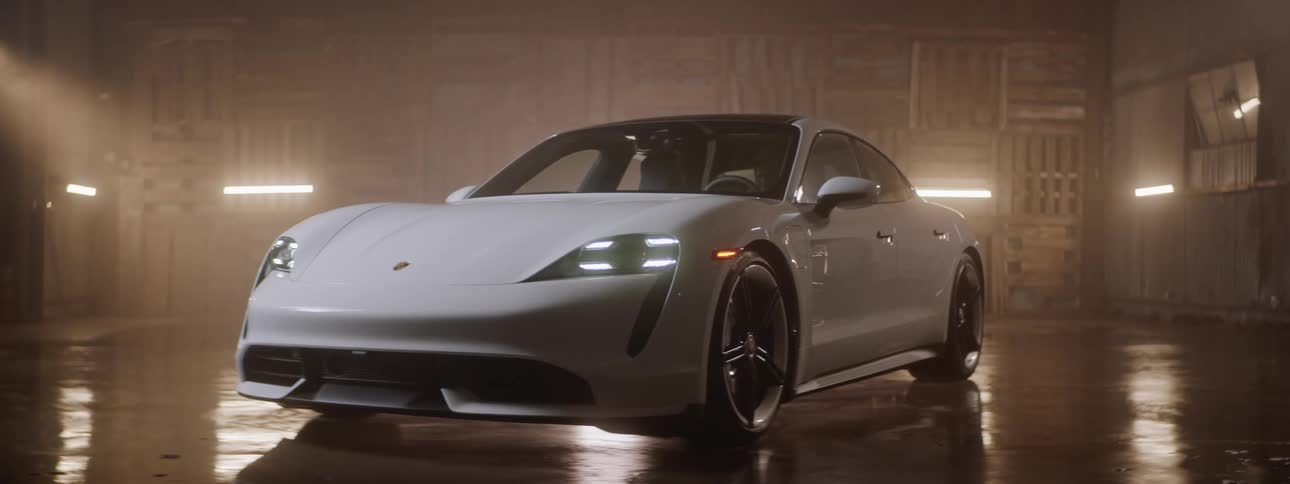 A white sports car sitting in a closed space with the headlights on then off