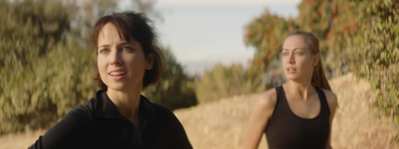 Two women jogging pause and stare when one grabs her friend and pulls her away