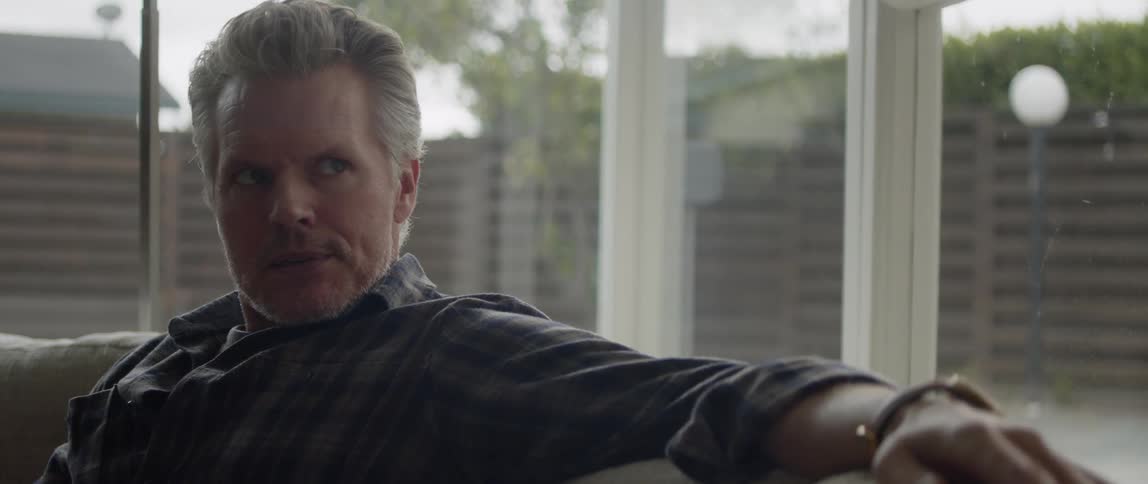 There is an older white man that is sitting on a couch and relaxing