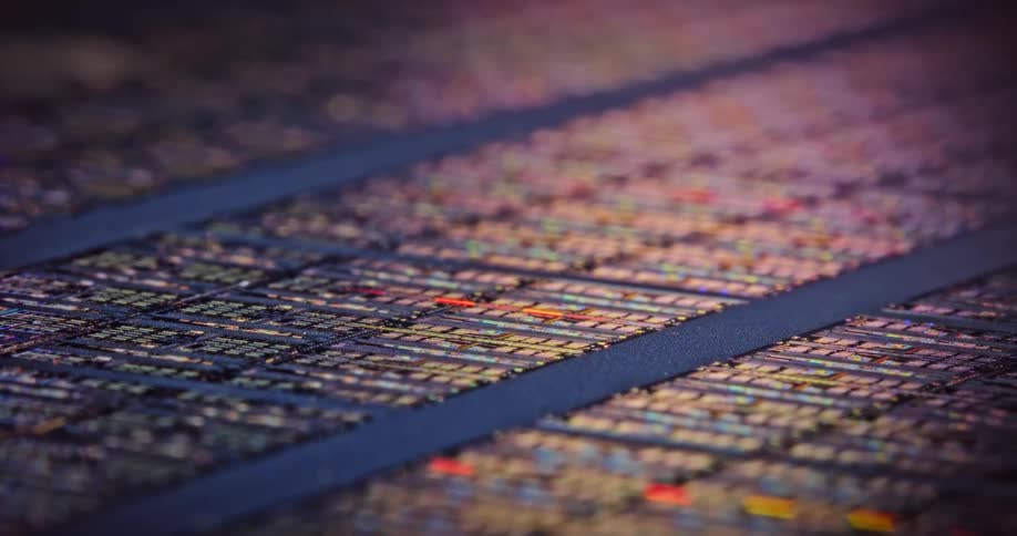 Light shines upon textured squares as they lay across a dark blue surface in rows