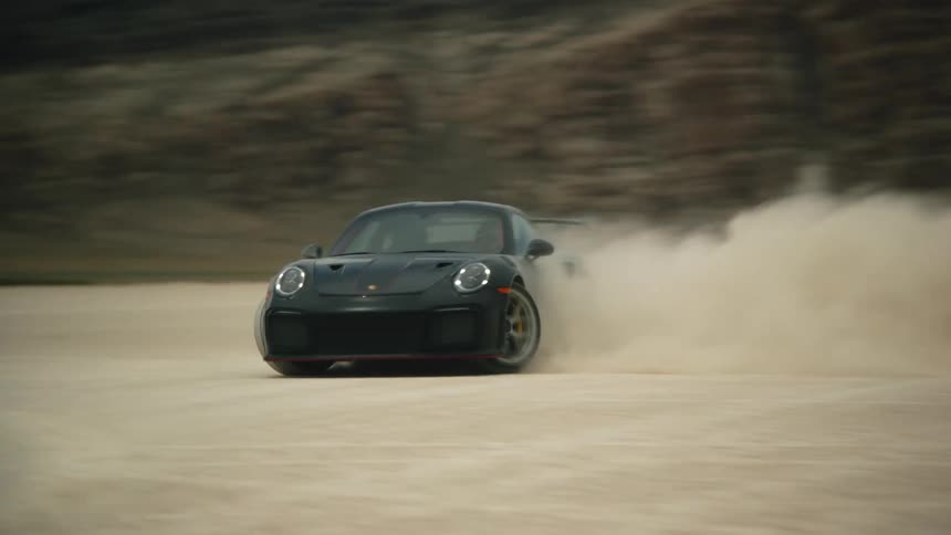 Shot of a muscle car drifting on the dunes behind a mesa