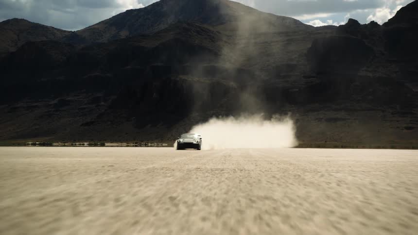 A vehicle leaves a trail of dust while speeding through the desert
