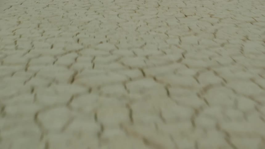 Cracks cover pale yellow arid ground