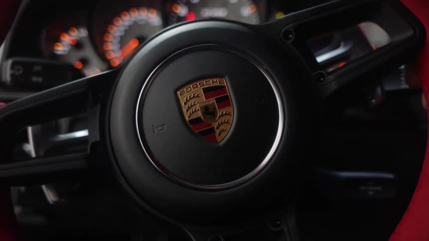 A driver turns the steering wheel in their sports car