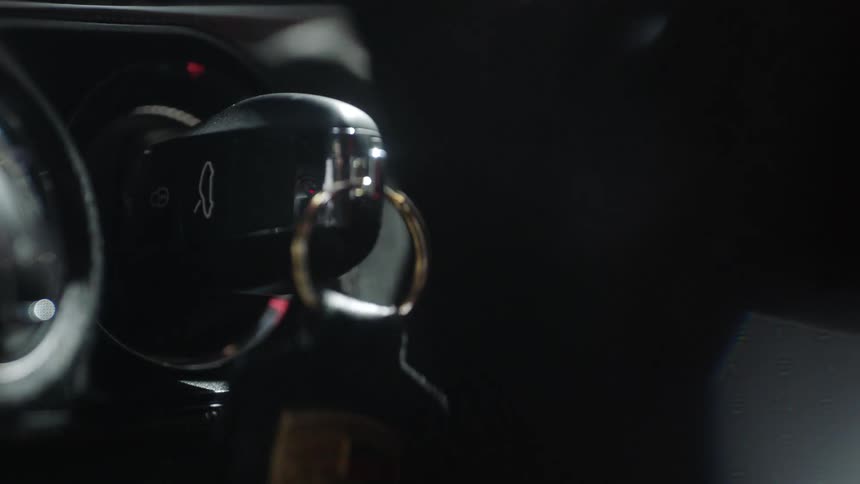 A person inserting then removing an electronic keyfob from a car