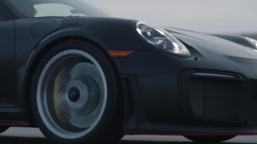 A sports car speeds down a rural highway