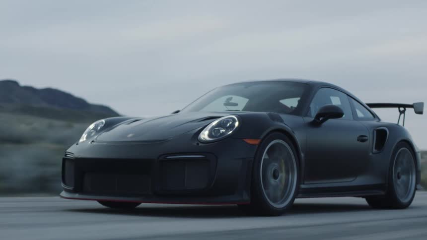 Dark sports car drives on highway