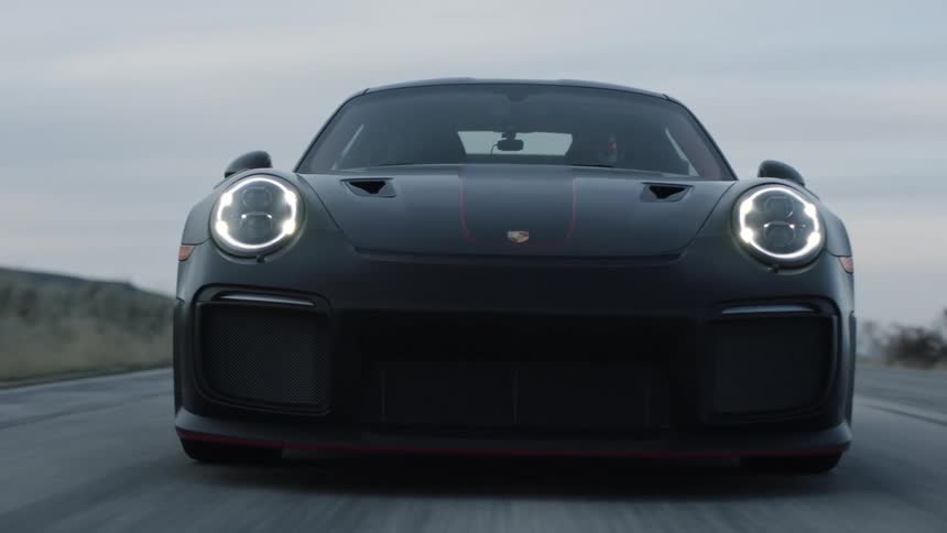 Black sports car drives highway on a cloudy day