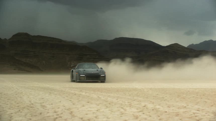 A car is driving off road in a desert area
