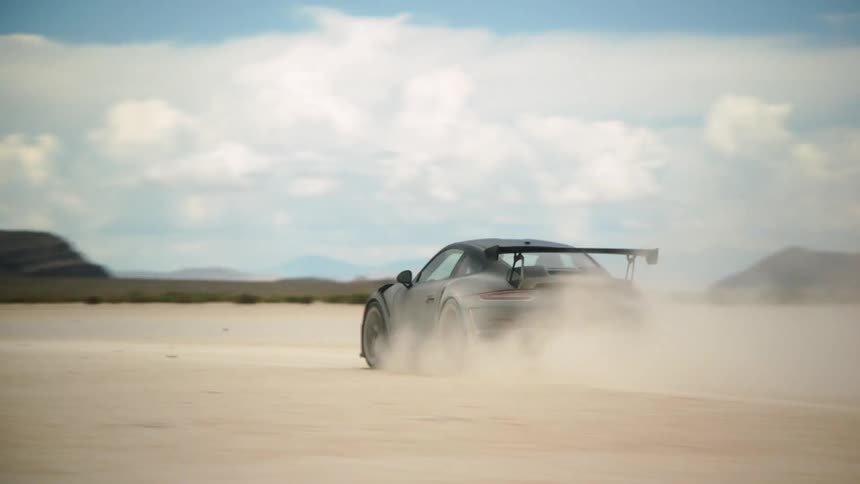 Black sports car drives in the desert