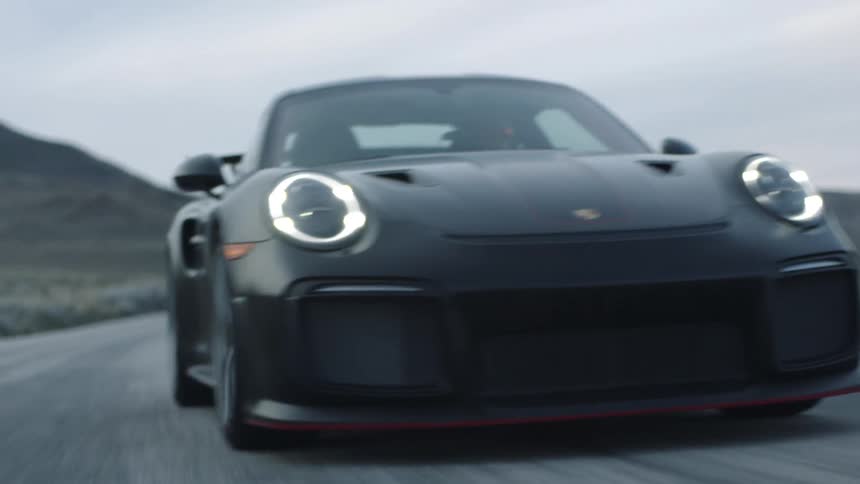An up close of a black sports car driving down the road