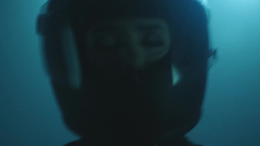 A woman wearing a full face helmet with a clear shield shaking and looking concerned