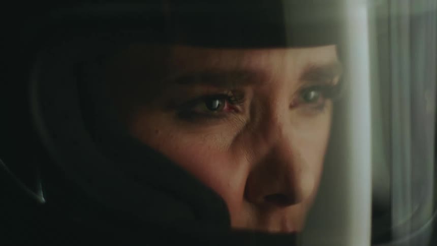 Sad woman in black helmet looks into space