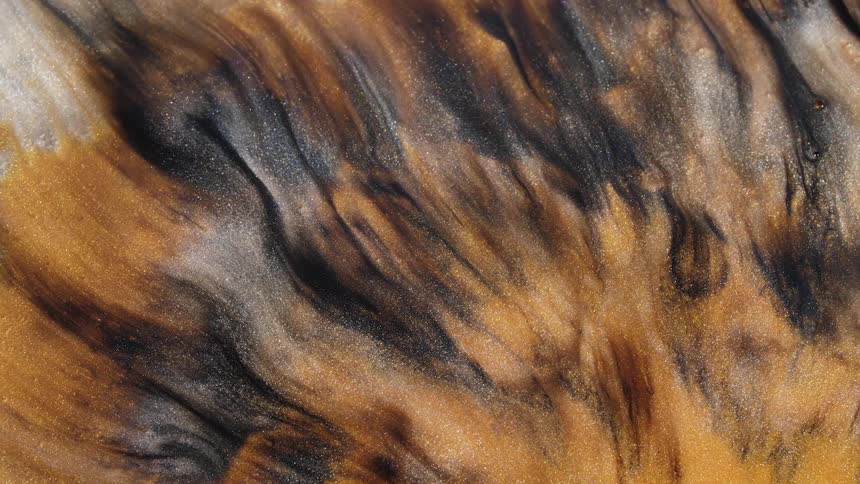 Golden and black sandy liquid flowing