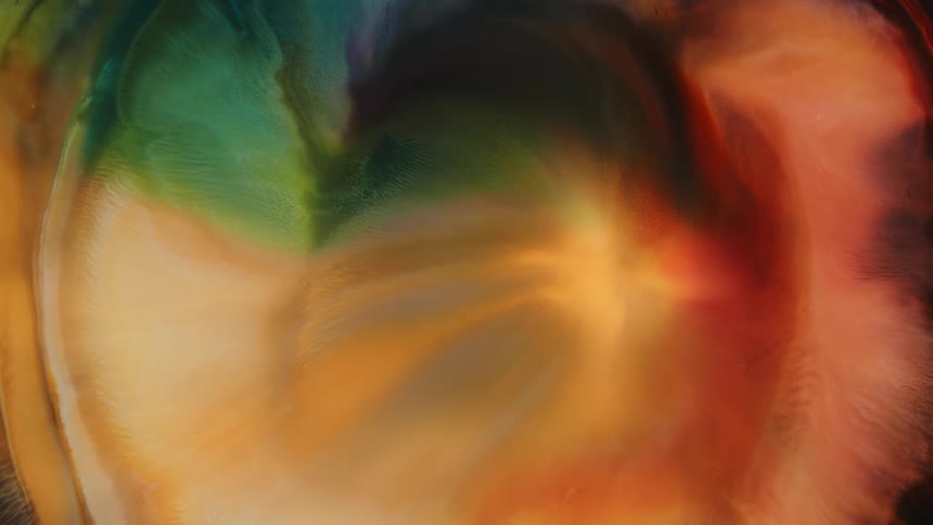 Orange colored paints swirling and folding together