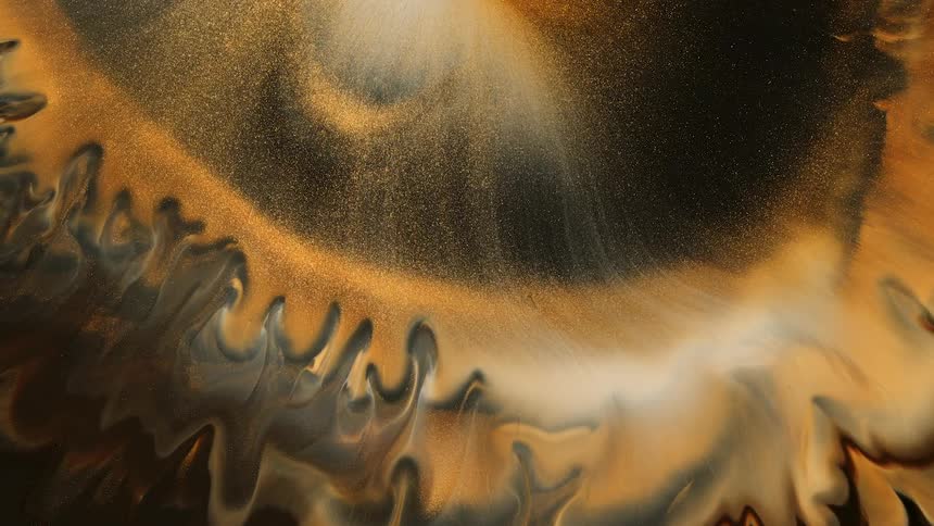 Abstract golden and white paint are mixing together on the canvas