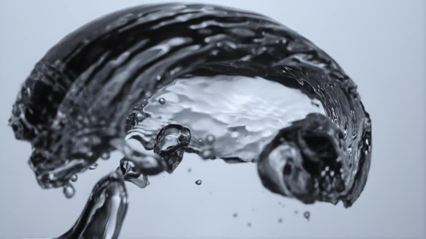 Bubbles and droplets in clear liquid surge upwards rising and shimmering