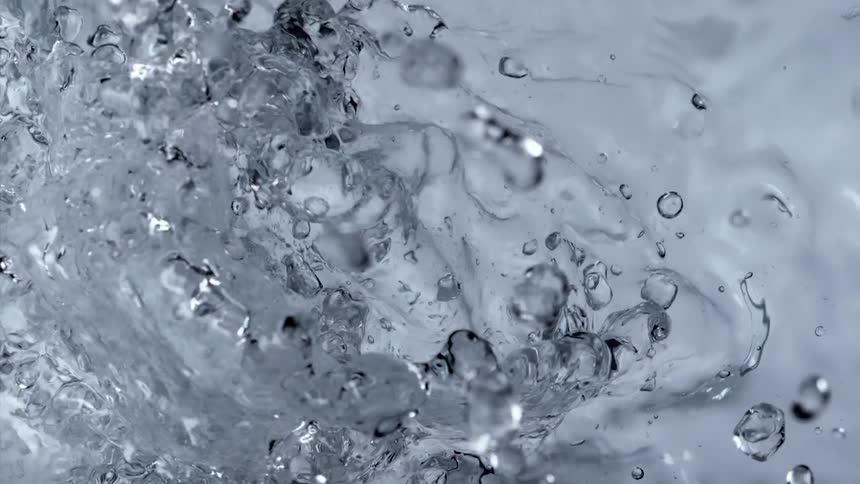 Bubbles are rising up over the surface of water and rippling in the light