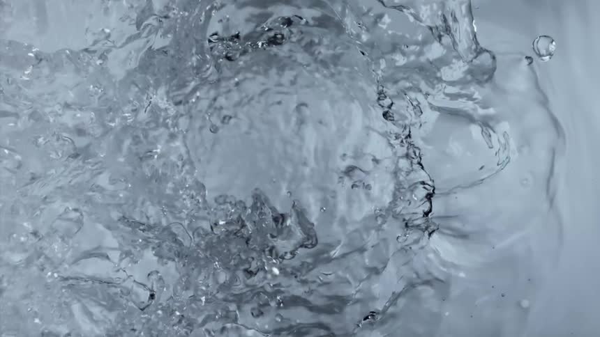 Clear liquid splashes up and the surface ripples
