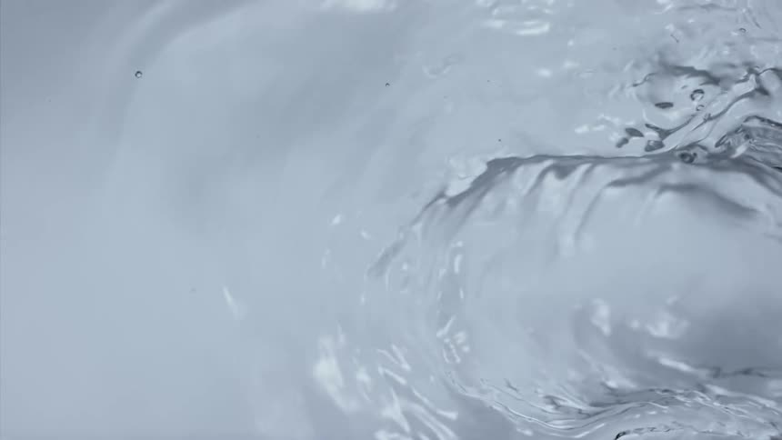 A bubble of water grows larger and splashes upward