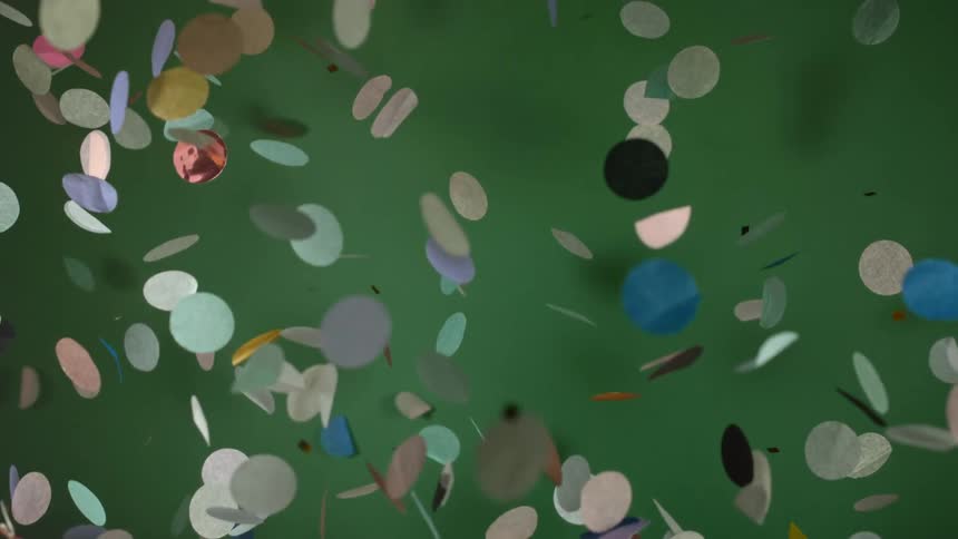 Confetti slowly falls against the wall