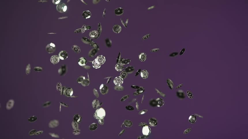 Silver sequins being thrown up in the air and falling down