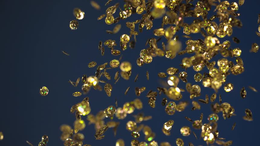Large pieces of gold confetti are tossed in the air