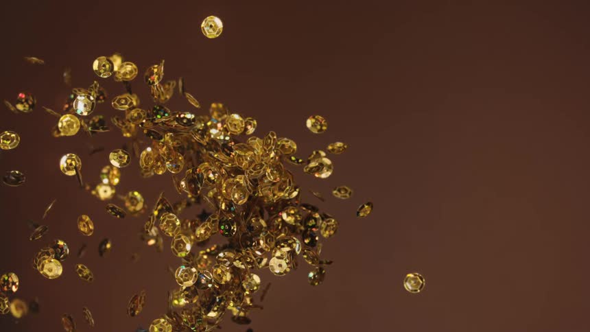 Shiny gold coins spin and turn as they fly up into the air and fall back down to where they came from