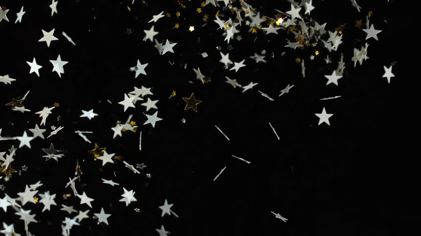 white and golden stars are being thrown across the screen with a black backdrop