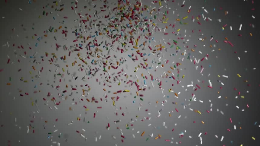 Colorful pills are being thrown into air on gray background