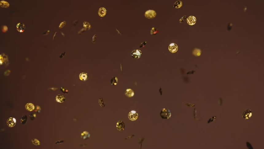 Gold sequins moving in the air