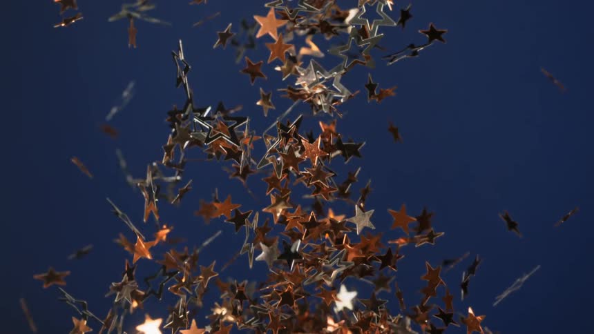 Copper and silver star shaped confetti explodes after being tossed up