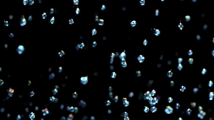 Abstract footage of tiny glass beads bouncing and flying in slow motion