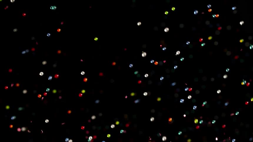 tiny colorful spheres bounce and float in the darkness