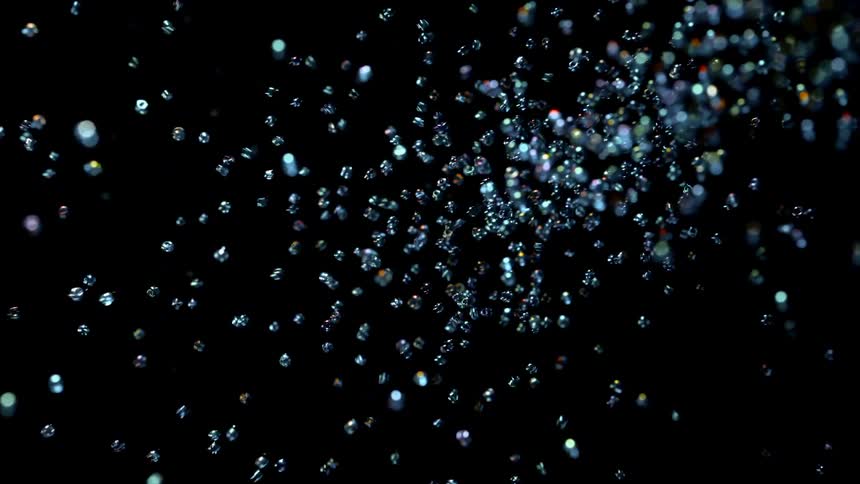 Abstract footage of micro pearls flying into the frame and bouncing