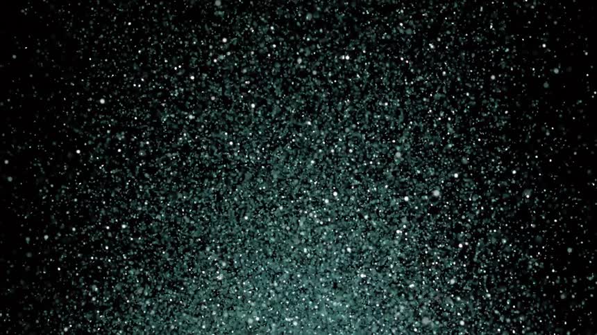 A massive cloud of glitter explodes into the air on black background