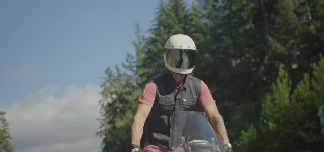 Motorcyclist standing up as he's riding his motorcycle