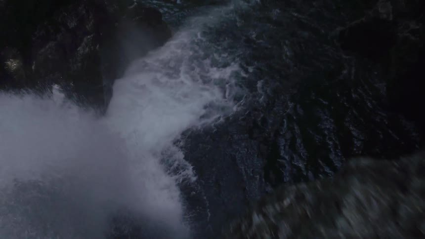 A waterfall over a curving cliff
