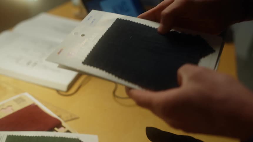 A woman checks fabric swatches on cardboard
