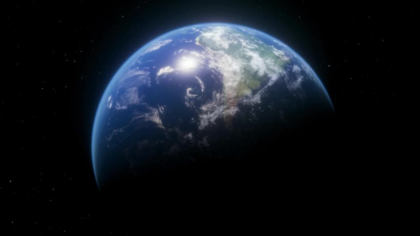 The earth slowly rotates in darkness of space