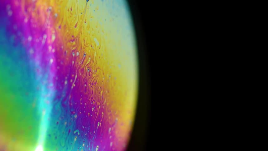 Rainbow colored fluid drips upward in an animation