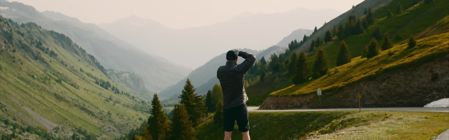 A man is hiking by the mountains with a camera