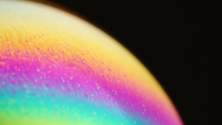 Colorful layers contained in sphere move against each other contrasting with black background