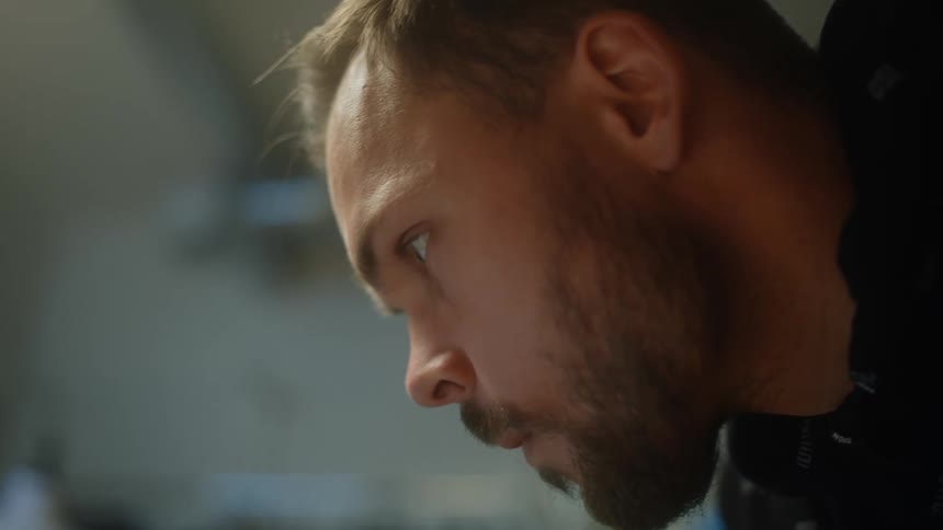 A man is looking down and then moves his eyes to look to his side