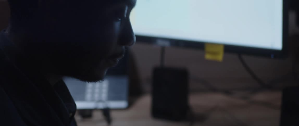 Man working at desk in office near computer checks paperwork numbers using a calculator